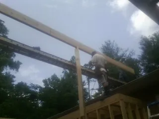 Carpenter setting a ridge beam over a new addition frame — Ice Dam Removal by Roofing Brothers in Lewisport