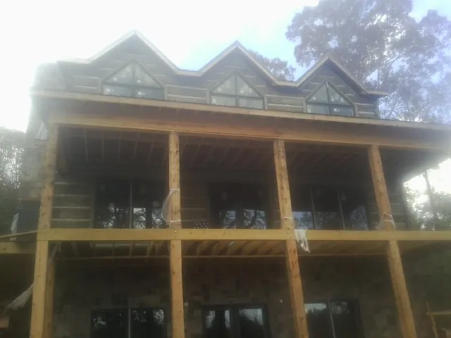 Dormers and porch framing on a large log home under construction — Roof Coating work by our crew in Lewisport