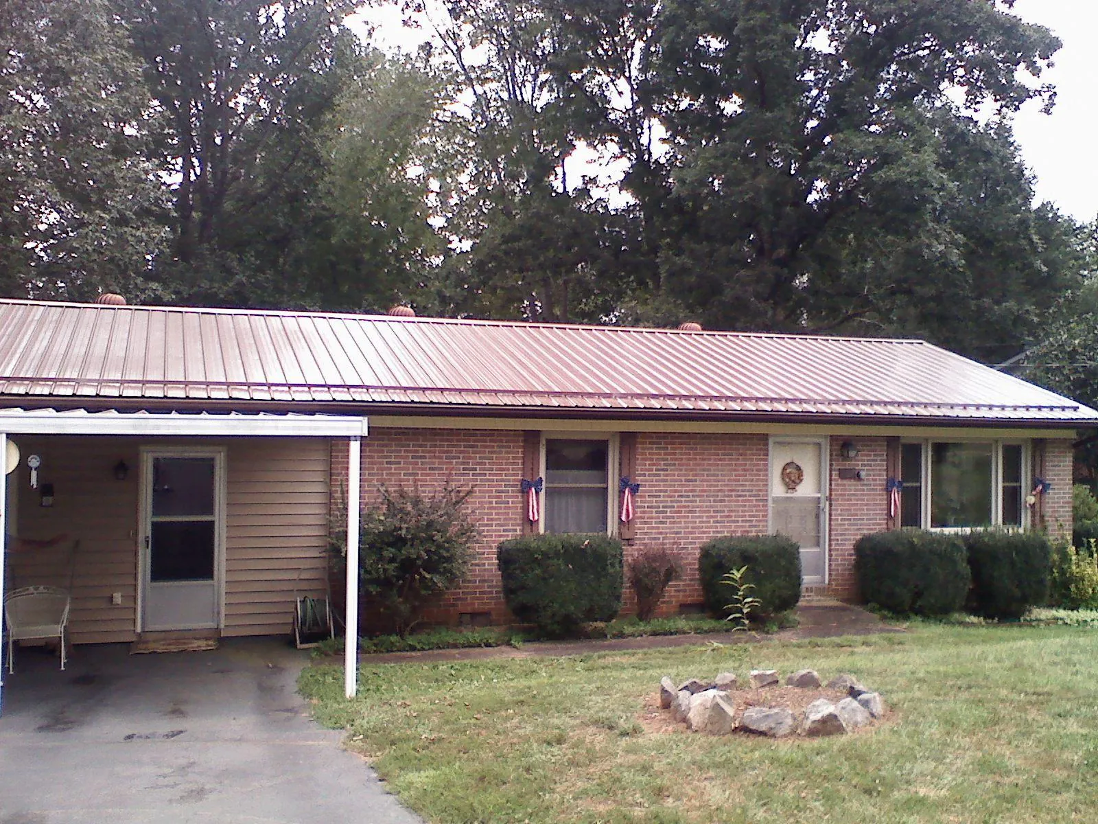 Bronze metal roof and carport on a brick ranch home — Roof Repair work by our crew in Lewisport